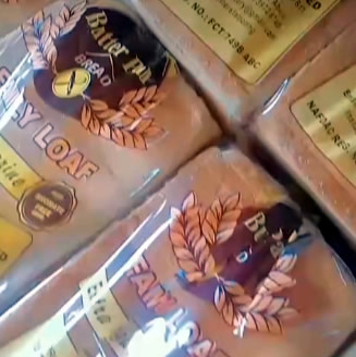 Close-up of packaged loaves with yellow labels and a laurel wreath emblem on the boxes.