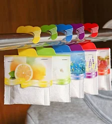 Row of colorful fruit-flavored drink pouches hanging on a rack, with a lemon label on the front left item.