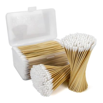 Open plastic case with bundled wooden cotton swabs with white tips, and a group of swabs standing upright beside it.