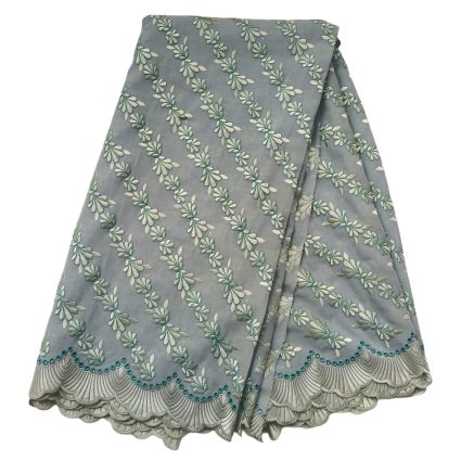 Light blue fabric with teal and cream floral embroidery arranged in diagonal rows and a scalloped teal-trimmed border.
