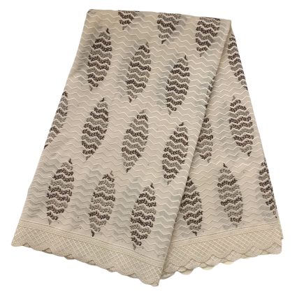 Beige lace fabric folded with diagonal brown embroidered leaf motifs and a scalloped patterned border along the edge.