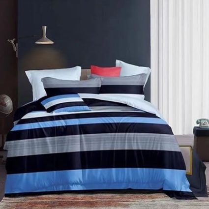 Bed with blue and navy striped bedding and white pillows in a modern bedroom with dark walls and sheer curtains beside.