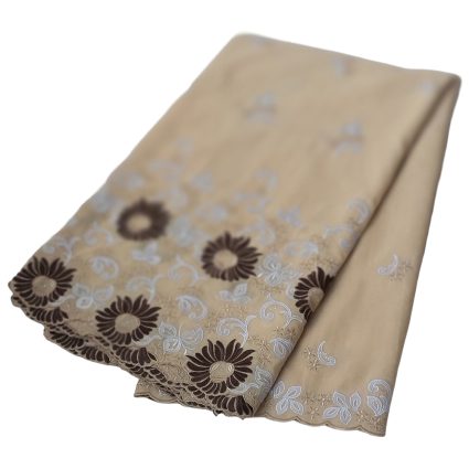 Beige fabric with white and brown floral embroidery along the border, folded to show the decorative edge.