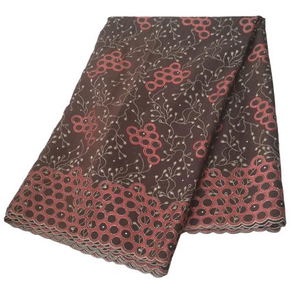 Folded brown fabric with red circular clusters and delicate beige vines, scalloped edge visible.