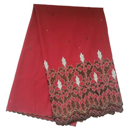 Red fabric folded with an ornate brown and white embroidered border along the bottom and a scalloped edge.