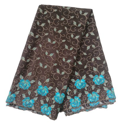 Brown lace fabric with turquoise blue floral embroidery along the scalloped edge, folded to show vine patterns.