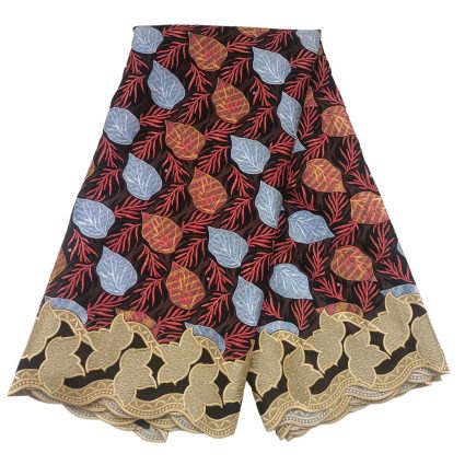 Layered African-print fabric with red branch-like leaves and blue and gold leaves on a black background, edged with gold scalloped lace trim.