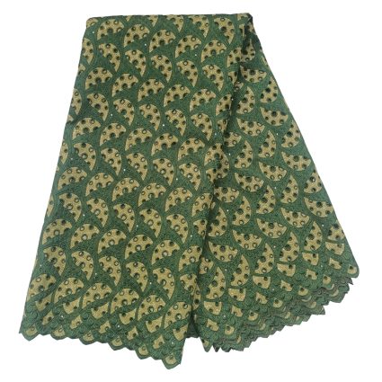 Stack of green and gold patterned fabric with repeating circular motifs and scalloped edges