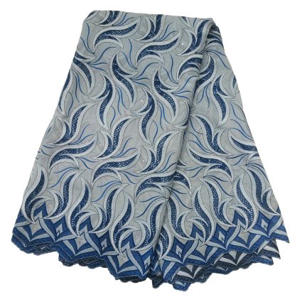 Fabric swatch with swirling blue and silver metallic embroidery on a pale blue background, folded to show a scalloped hem edge.