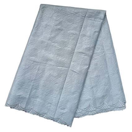 Light blue lace fabric folded, showing a scalloped edge and delicate embossed pattern