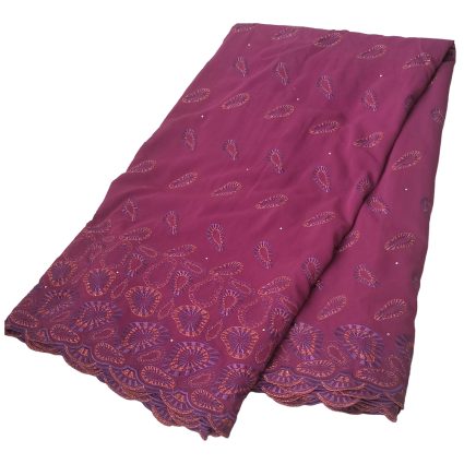 Folded magenta lace fabric with circular embroidery along the edge, scattered across the material