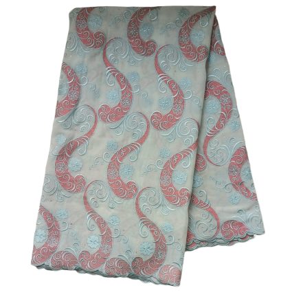 Folded decorative fabric with red paisley swirls and light blue floral motifs on a pale blue background.