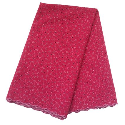 Pink fabric with a repeating circular lace-like pattern and scalloped edge, likely a hemmed textile sample or skirt fabric.