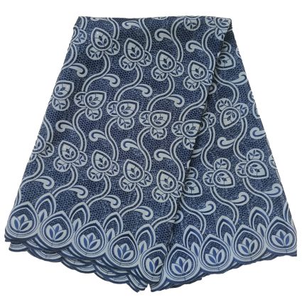 Folded blue patterned fabric with a floral scroll design in navy and light blue tones, showing a decorative border edge