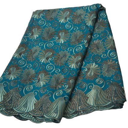 Teal fabric with silver floral and swirl pattern, folded to show decorative edge.