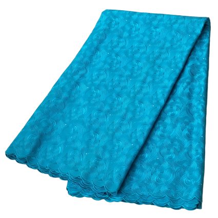 Turquoise lace fabric folded, featuring a circular swirling pattern and scalloped edge.