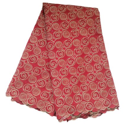 Red fabric with a gold spiral pattern and scalloped edges, folded to show its decorative design in a rich, red color.