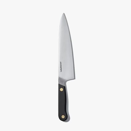 Kitchen chef's knife with a black handle and brass rivets.