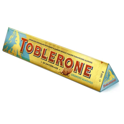 Toblerone Crunchy Almonds chocolate bar in yellow-blue wrapper, shown as a long triangular prism with the mountain logo and bold red lettering.