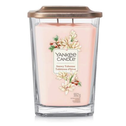 Pink Yankee Candle in a clear glass jar with copper lid; label reads Snowy Tuberose and floral design (552 g).