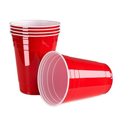 Red plastic cups on a white background, with several stacked cups and one tipped over on its side.