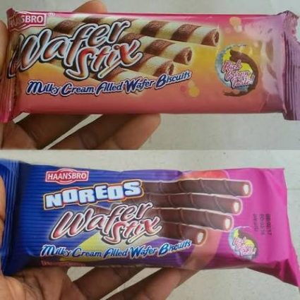 Two wafer biscuit bars in bright pink and blue packaging are held in a hand, labeled Milk Cream Filled Wafer Biscuits (snack wrappers).